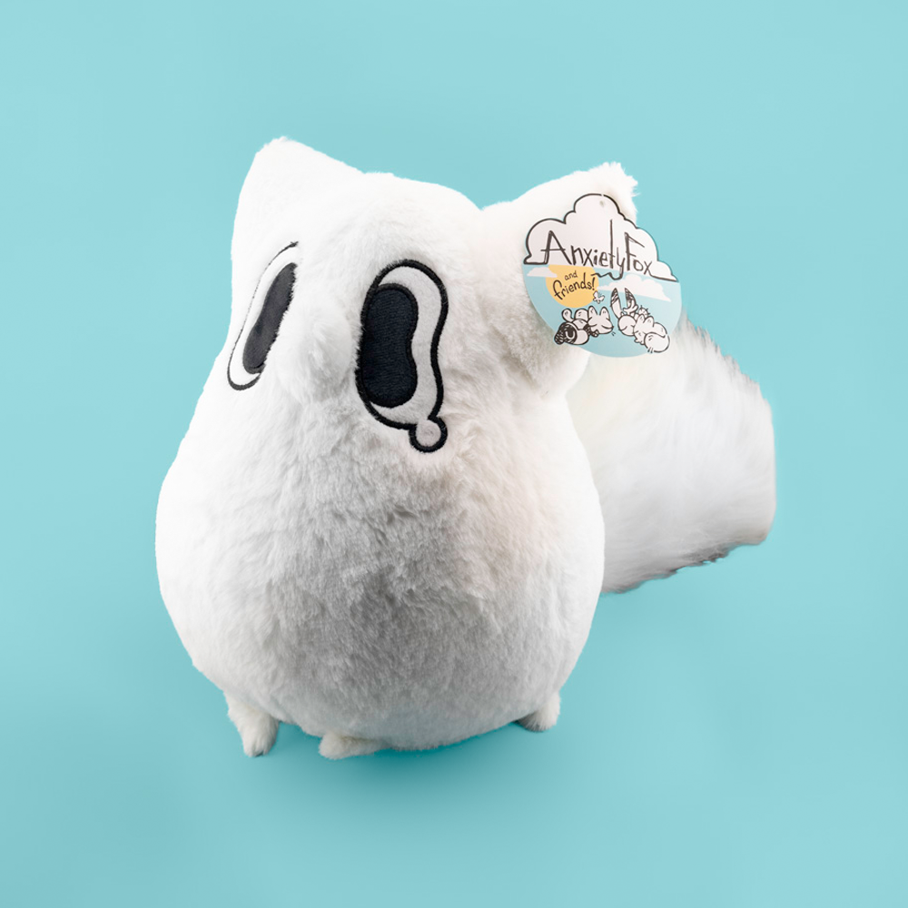 White plush toy of a fox with black accents on a light blue background