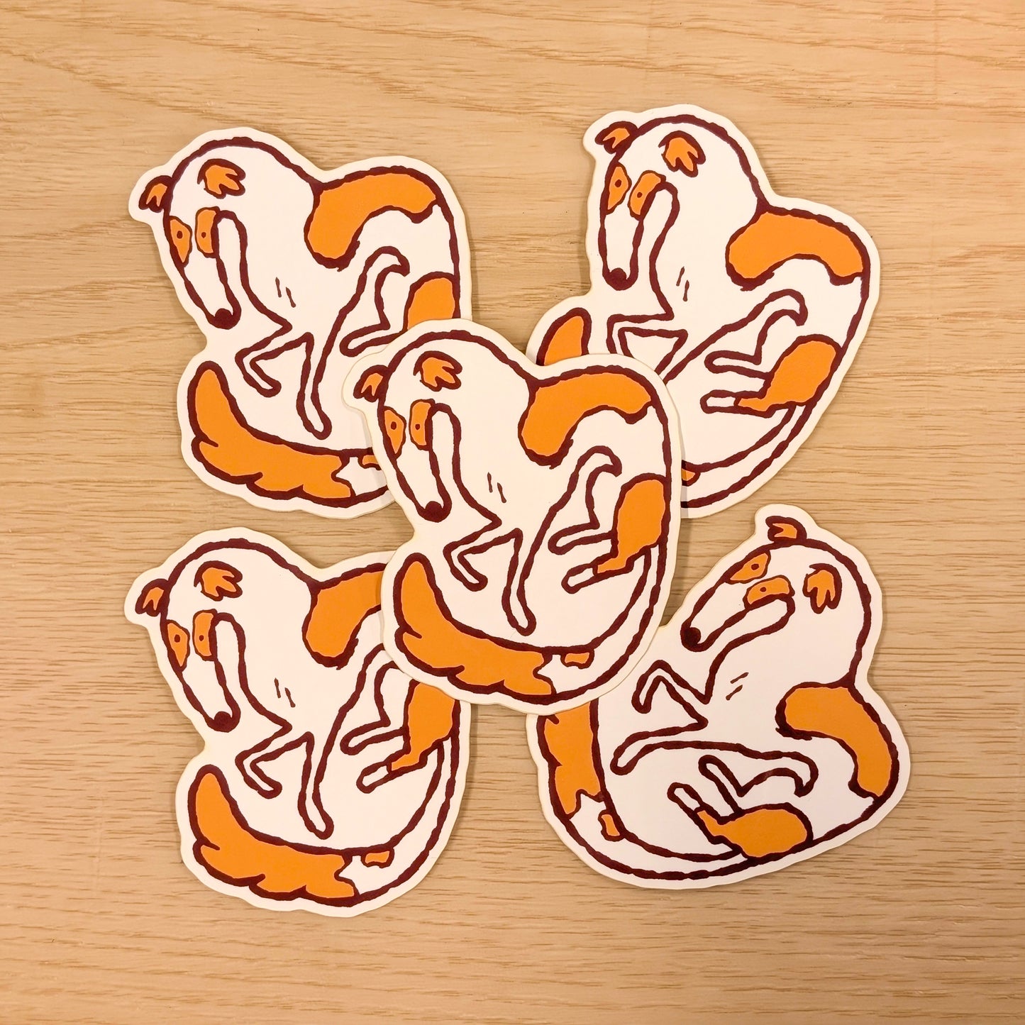 Four Borzoi stickers with orange and white design on a wooden surface