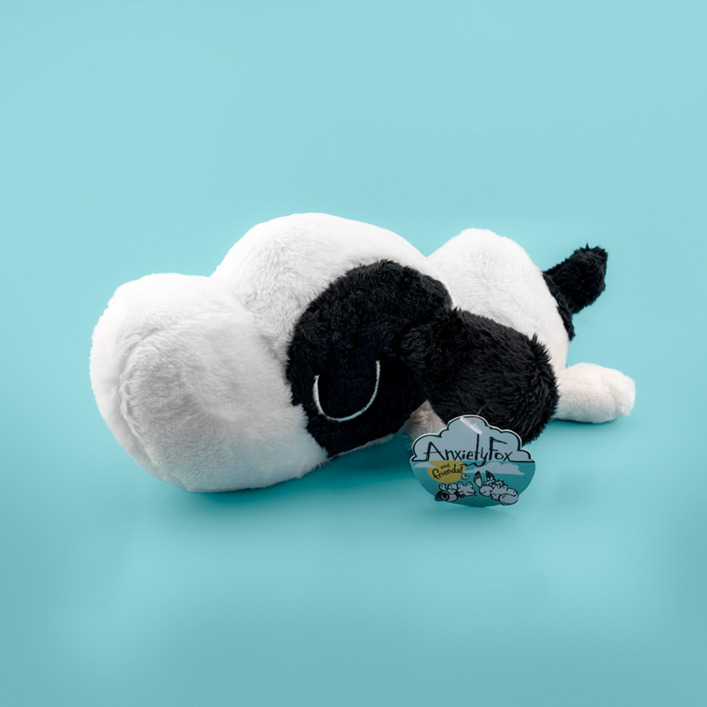 Plush toy of a black and white puppy on a light blue background