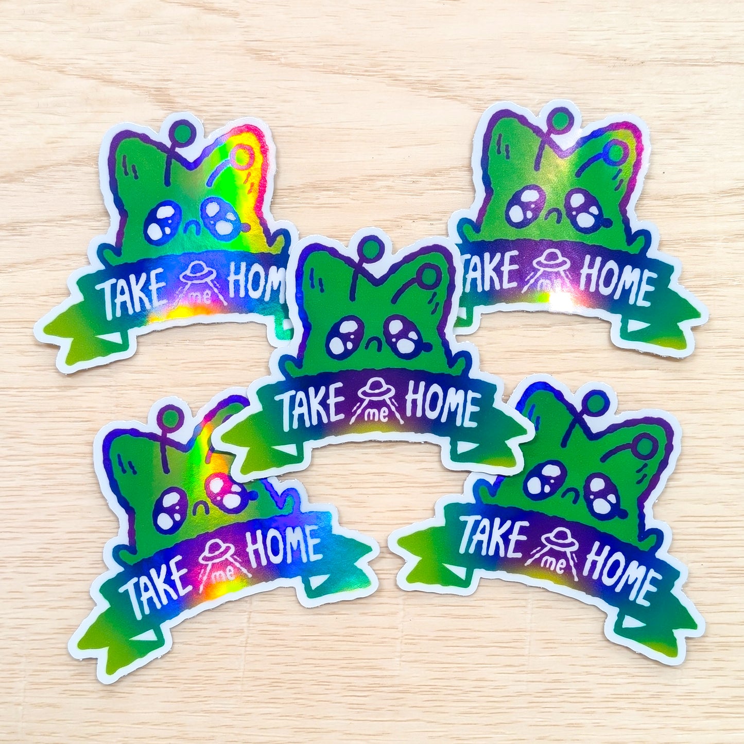 Colorful stickers with 'Take me Home' text on a wooden surface background