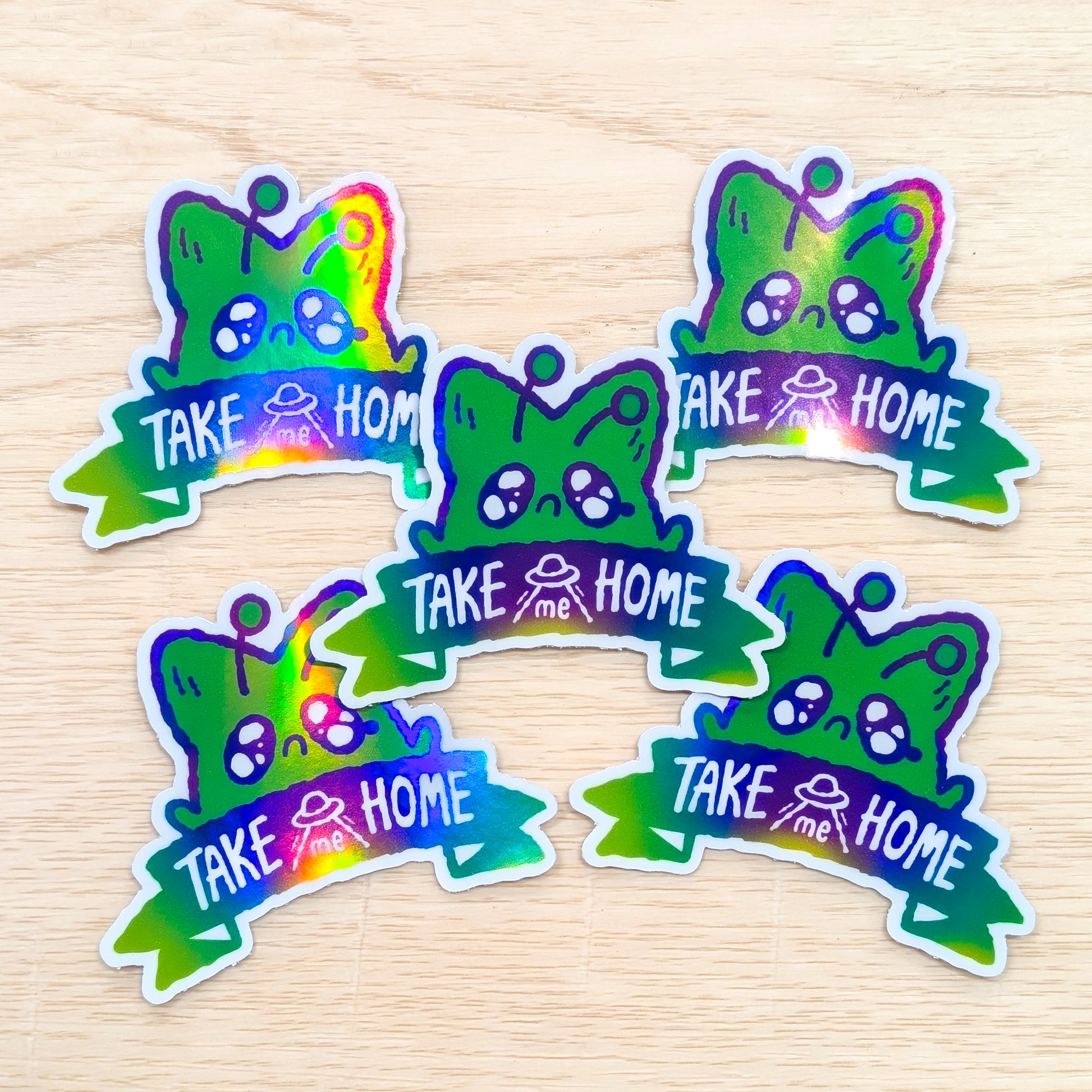 Colorful stickers with 'Take me Home' text on a wooden surface background