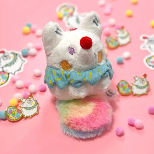 White fox plush toy with a colorful tail on a pink background with decorative elements, wearing a clown outfit.