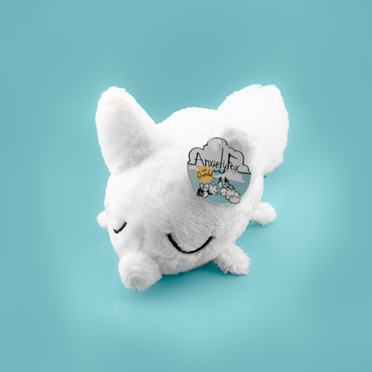 Plush toy of a white fox against a light blue background