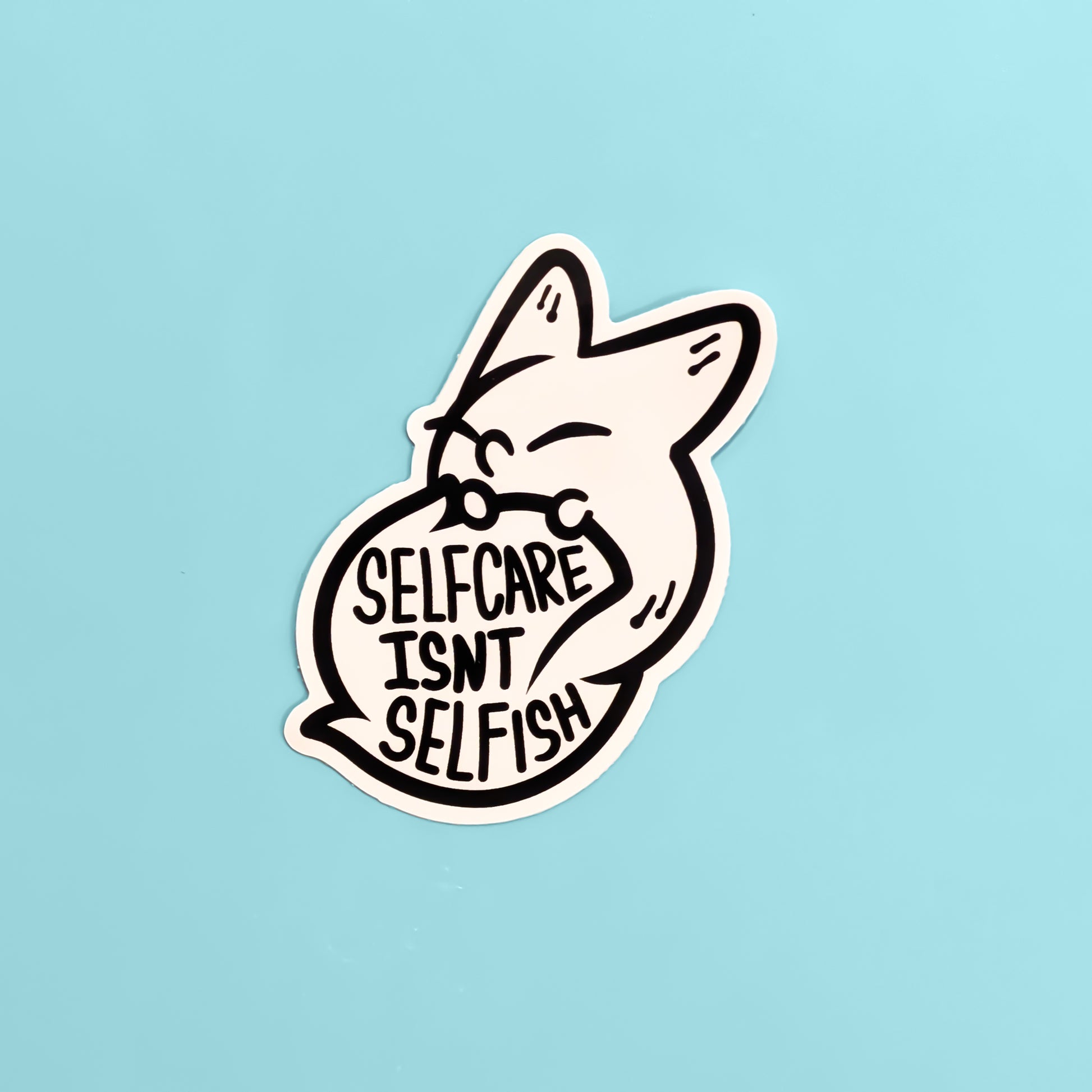 Sticker with a fox design and 'Self care Isn't Selfish' text on a light blue background