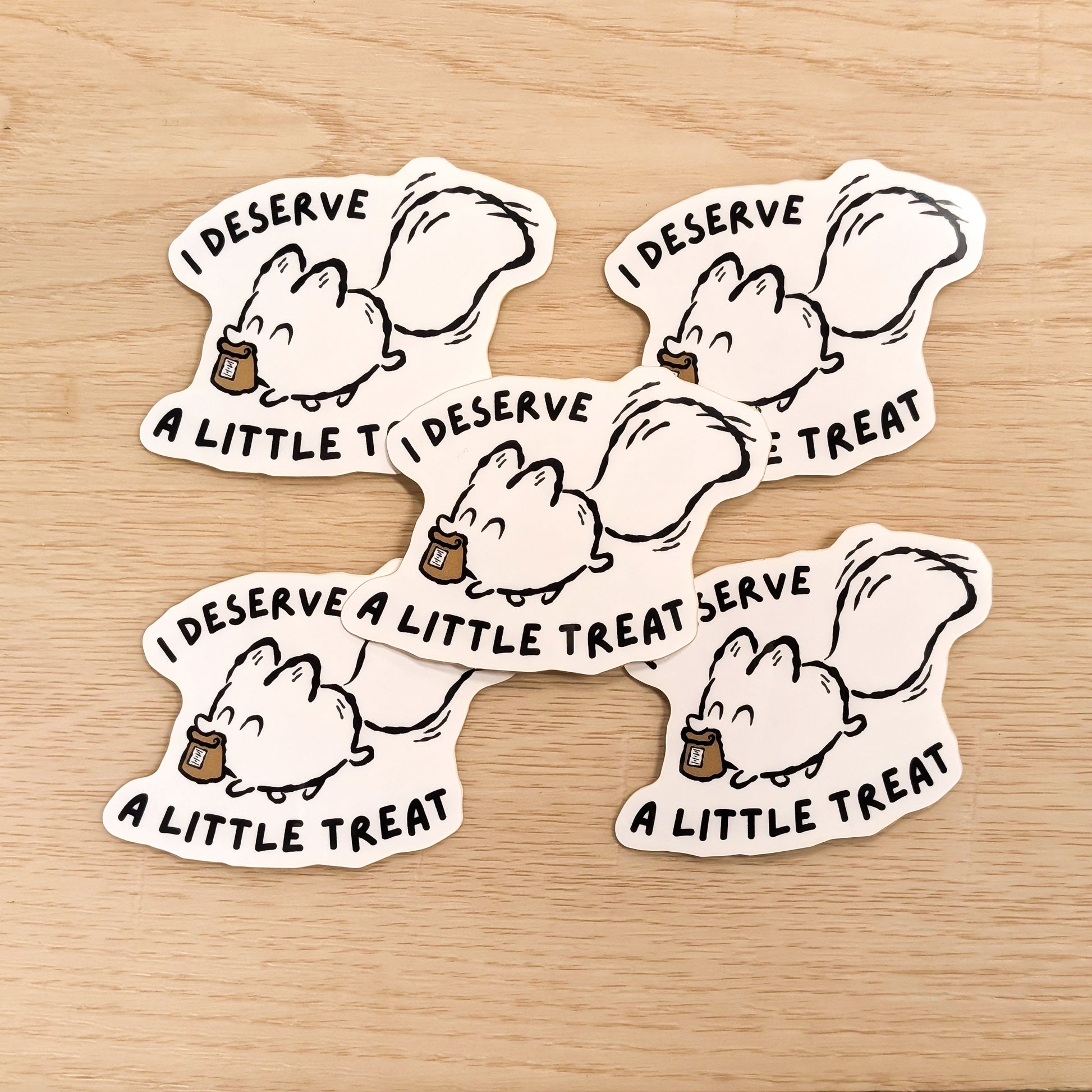 Five cartoon white fox stickers with text on a wooden surface