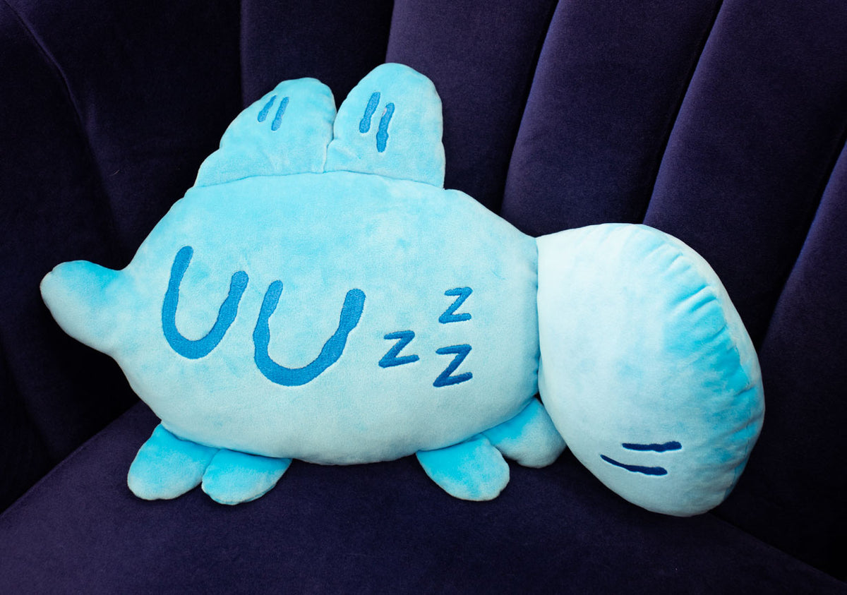 Soft plush toy cushion from Made by Nao! featuring a sleepy face, perfect for comfort and playful decor.