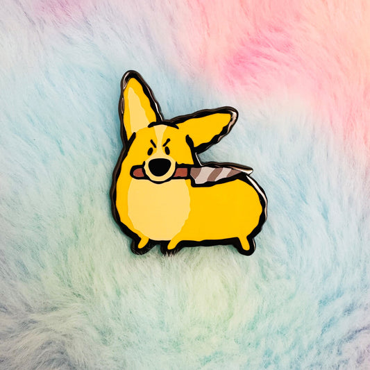 Enamel pin of a cartoon corgi holding a knife on a fluffy, multicolored background