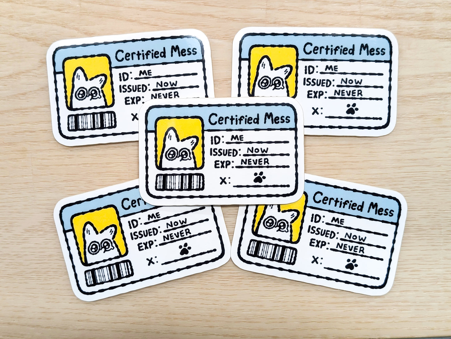 Five 'Certified Mess' stickers with a white fox illustration on a wooden surface