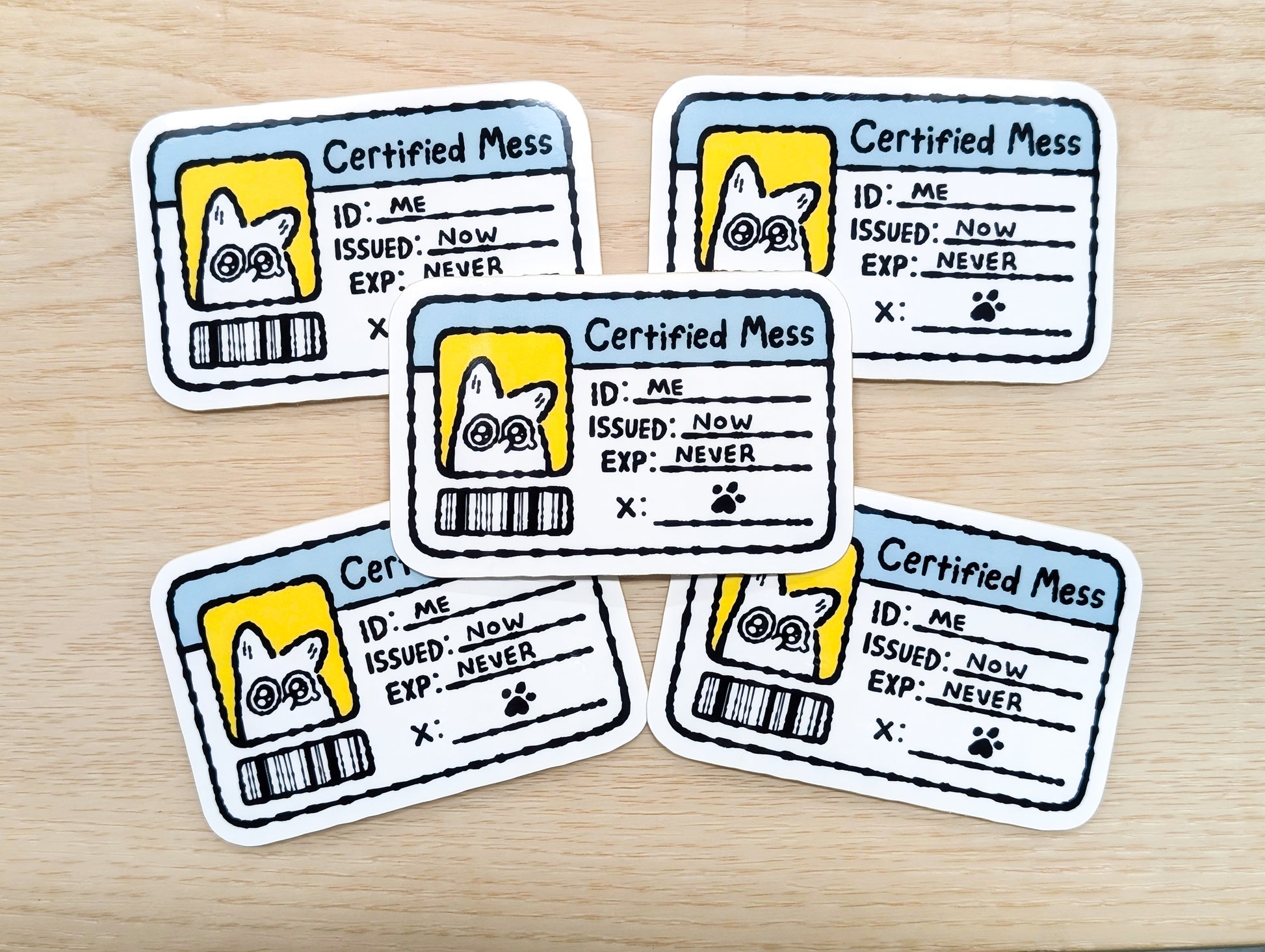 Five 'Certified Mess' stickers with a white fox illustration on a wooden surface
