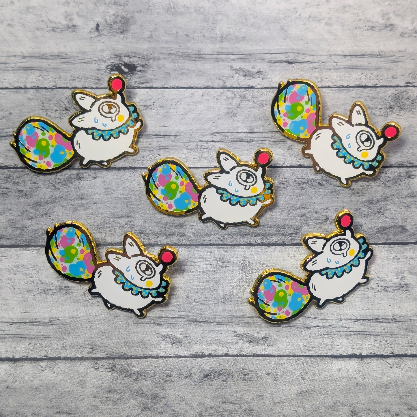 Set of colorful animal-themed pins on a wooden surface
