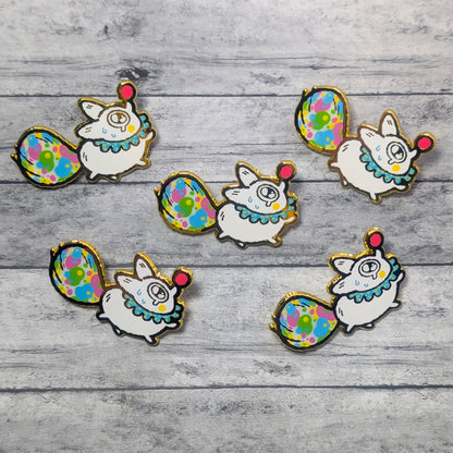 Set of colorful animal-themed pins on a wooden surface