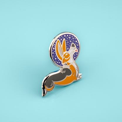 Enamel pin with a stylized corgi wearing a space helmet, on a light blue background