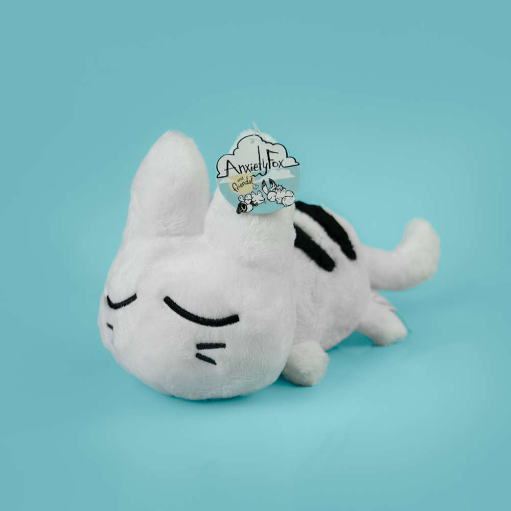 White plush cat toy with black accents on a light blue background