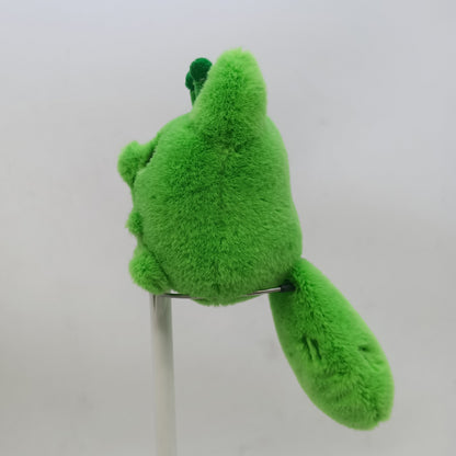 Green alien fox plush toy on a stand against a white background