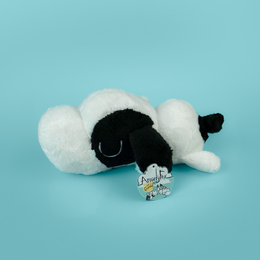 Plush toy of a black and white dog on a light blue background