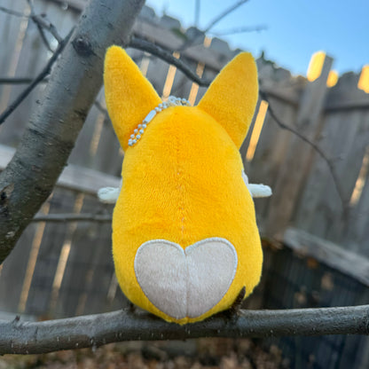 Back view of a plush toy of a corgi with a heart on its bottom