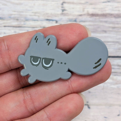 Enamel pin from Made By Nao! featuring a small annoyed face with a hand gesture, part of the Smol Feelings mood pin collection.