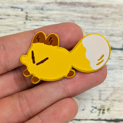 Yellow fox enamel pin from Made By Nao! Smol Feelings collection, featuring a cute fox holding its tail.