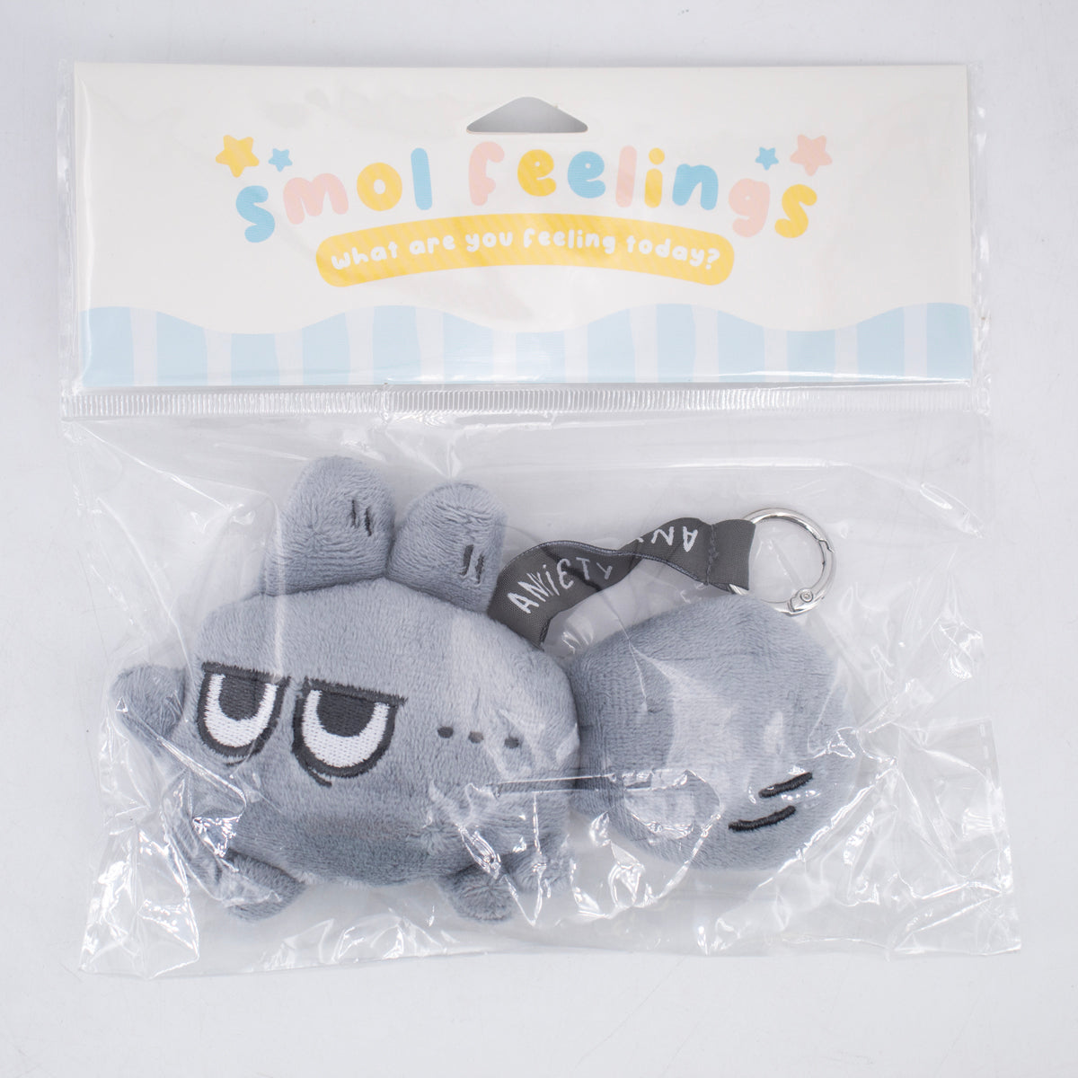 Smol Feelings plush toy by Made By Nao! showing an annoyed facial expression in its packaging. Soft, colorful mood plush.