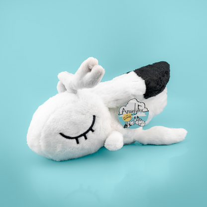Plush toy of a white rabbit with black accents, against a light blue background