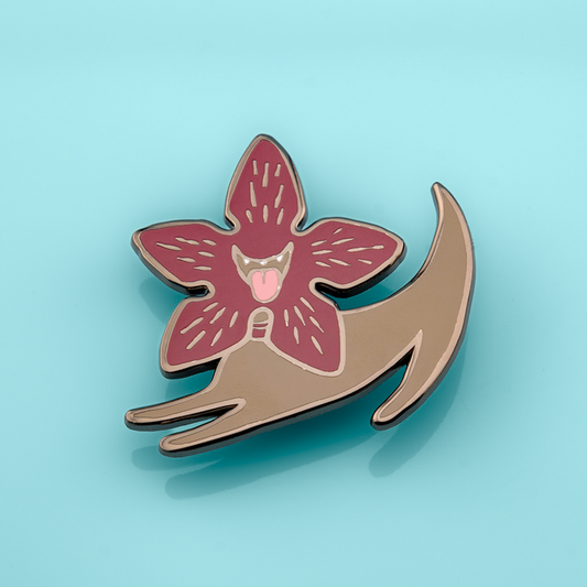 Made By Nao! Demodog enamel pin featuring a detailed, colorful dog design on a metal pin backing.