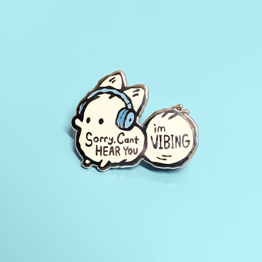 Anxiety fox enamel pin from Made By Nao! with the phrase "Sorry, Can't Hear You, I'm Vibing" on a colorful design.