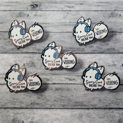 Anxiety fox enamel pin featuring the phrase "Sorry, Can't Hear You, I'm Vibing" in black text on a silver-toned pin by Made By Nao.
