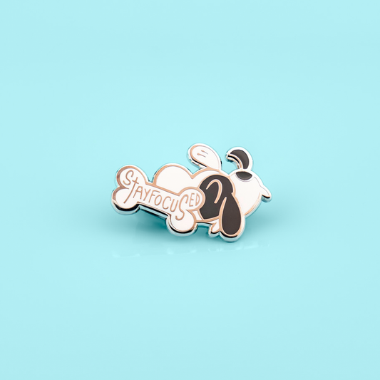 Stay Focused ADHD puppy enamel pin by Made By Nao! features a cute puppy design with motivational text, perfect for jackets or backpacks.