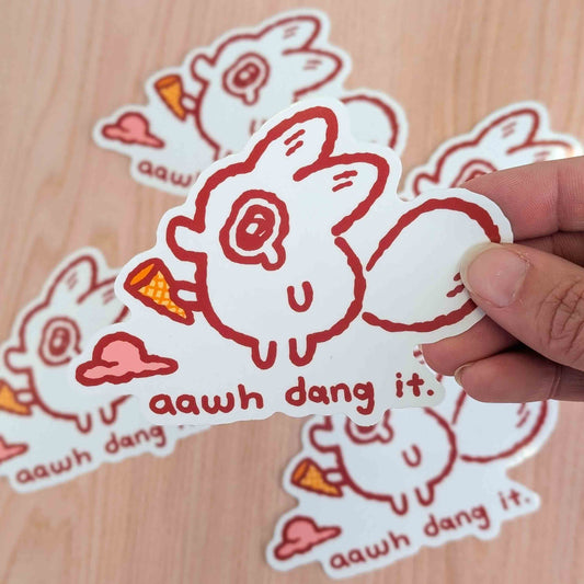 A vinyl sticker of an anxiety fox character from Made By Nao!, featuring a playful fox design with the phrase "Awh Dang It."
