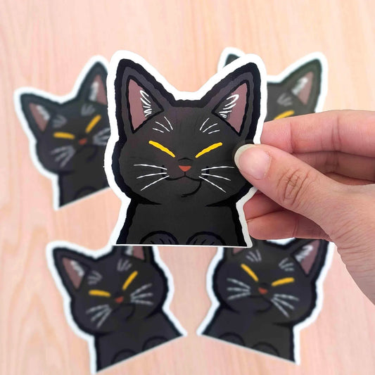 Black cat peeker vinyl sticker by Made By Nao! features a cute black cat peeking with wide eyes, perfect for decorating surfaces.