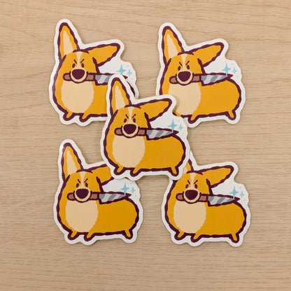 Vinyl sticker of Bug the Corgi with a knife design by Made By Nao! featuring colorful, playful dog illustration on adhesive sticker.