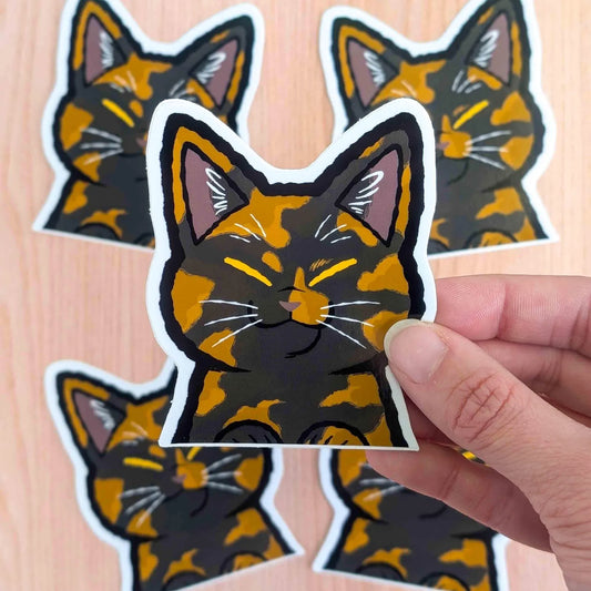 Tortoiseshell cat vinyl sticker by Made By Nao! featuring a cute peeking cat design on clear adhesive backing.