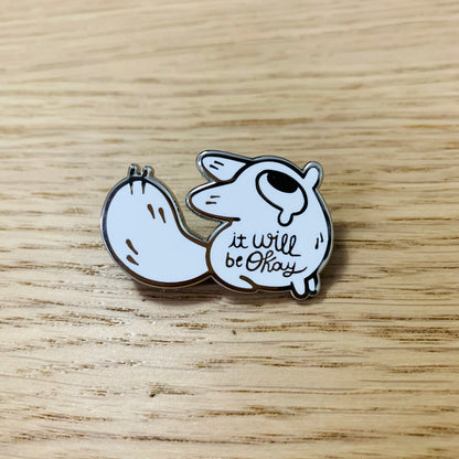 An enamel pin featuring a cute fox with the phrase "It Will Be Okay" by Made By Nao!
